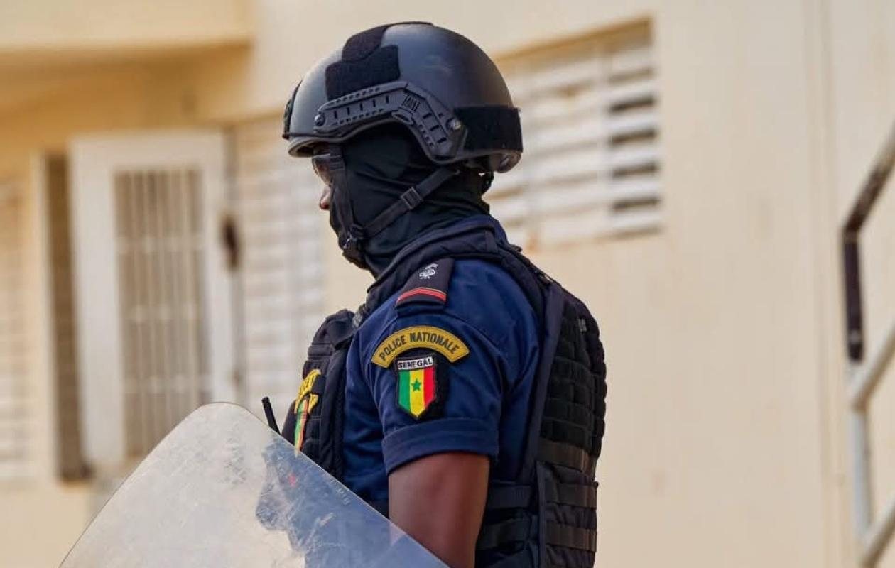 Agent de la Police nationale sénégalaise en tenue de maintien de l'ordre, casque et gilet